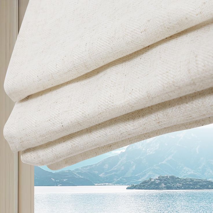 an open window with a view of the water and mountains