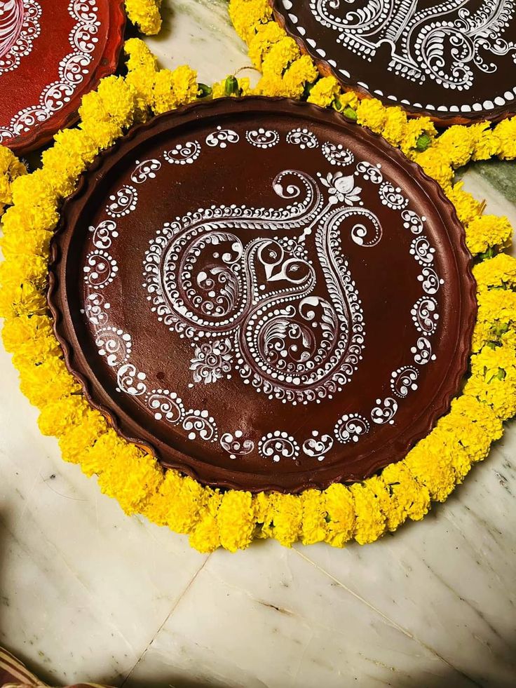 three decorative chocolate pies with yellow flowers in the middle on a marble table top