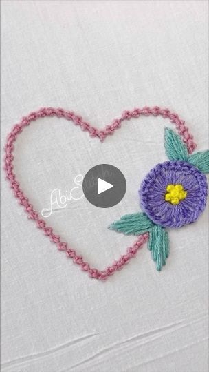 a video demonstrating how to make a crochet heart with flowers