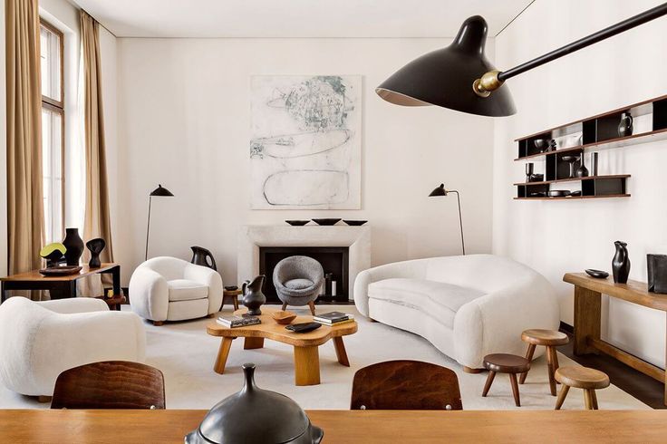 a living room filled with furniture and a large painting hanging above the fire place on the wall