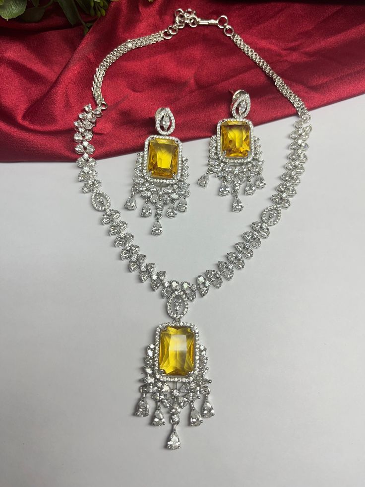 Gorgeous fine quality imitation jewellery  CZ Yellow with diamonds studded necklace with white gold rhodium plating and matching Earrings Item contains: Necklace and earrings AAA quality cubic zirconia used. Highest quality and craftsmanship Necklace Fitting is adjustable Earrings Closure: Pushback Necklace Closure: chain with Hook Details-  -Handmade item -Delivery from a small business in India -Materials: white rhodium, stones, cz, zircon, American diamond -Jewellery type: Earrings, Necklace -Style: Art deco *CARE INSTRUCTION* You can use Jewelry for years together with the help of below jewelry care instructions. * Protect from sharp blows/scratches and extreme temperature. * Avoid contact with perfumes, sprays, chemicals and water. * Keep in a clean, dry and airtight Zip-pouch. * Wipe Diamond Cut Cubic Zirconia Jewelry Sets For Party, Dazzling Cubic Zirconia Jewelry Set With Diamond Cut, Dazzling Cubic Zirconia Diamond Cut Jewelry Sets, Fine Silver Jewelry Set With Cubic Zirconia, Dazzling Diamond Jewelry With Matching Earrings, White Gold Jewelry Sets With Diamond Accents And Crystal, Fine Jewelry Silver American Diamond Jewelry Sets, White Gold American Diamond Jewelry Sets As Gift, White Gold American Diamond Jewelry Sets For Gifts