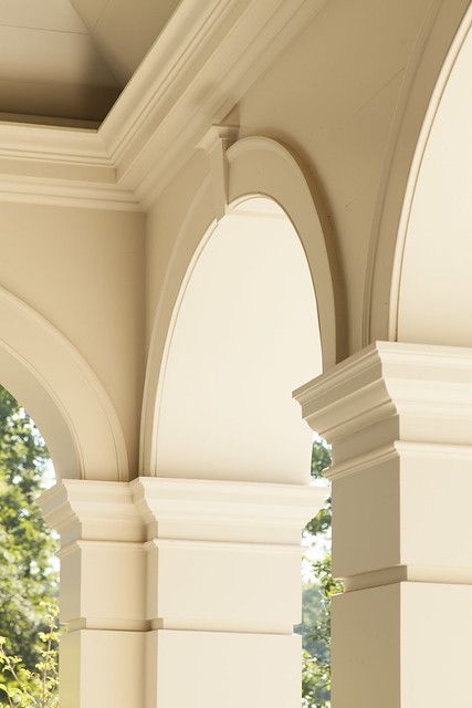 a clock is on the side of an arch in a building that has columns and arches