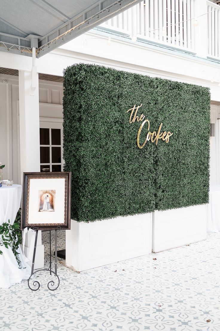 a wall covered in green plants with the words the cooker on it's side