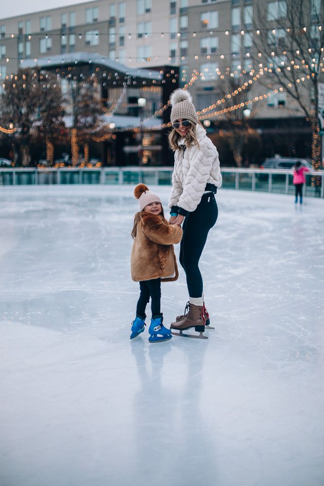 a woman teaching a child how to skate on an ice rink