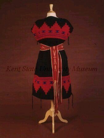 an old native american dress with red, blue and black designs on the neckline