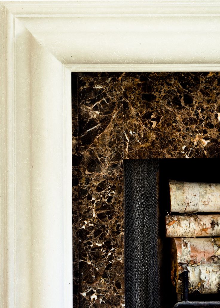 a fire place with a bunch of logs in the middle and a white frame around it