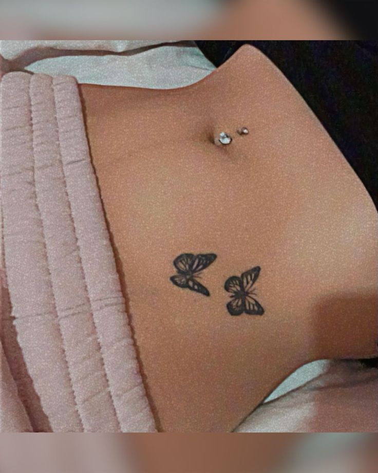 a woman's stomach with two butterflies on it