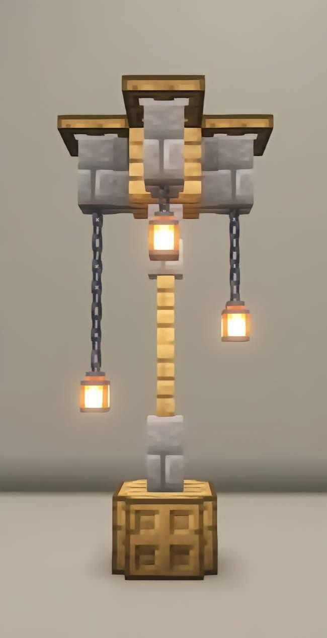 an image of some lights that are on top of a blocky structure with chains hanging from it's sides