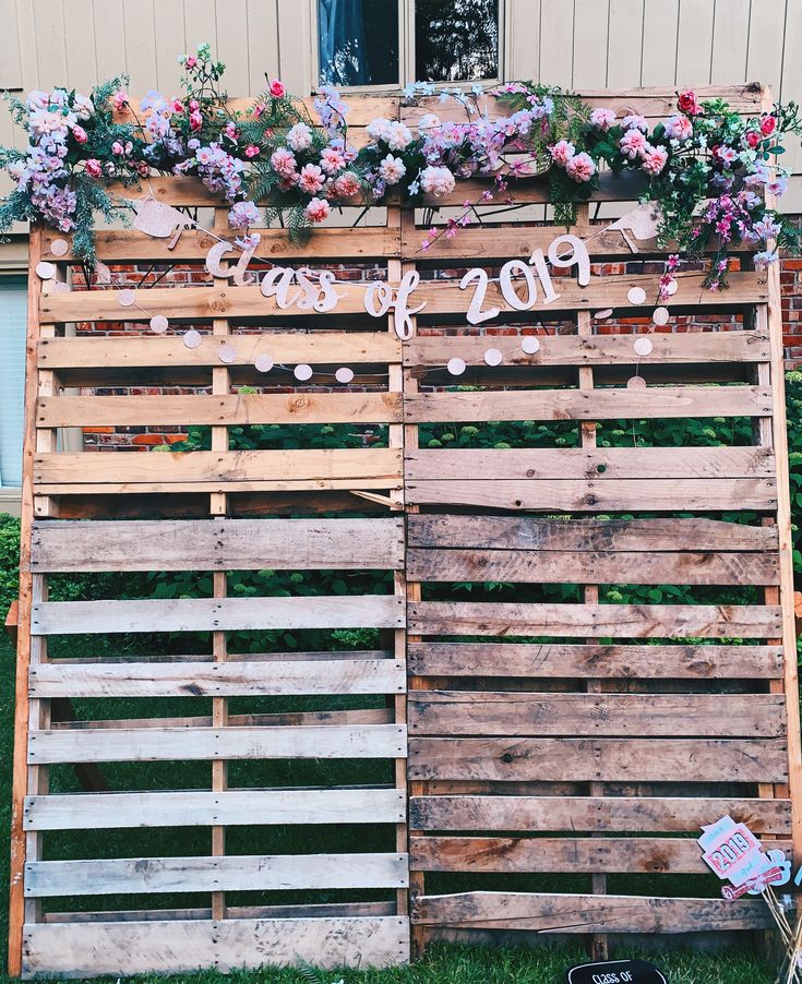 a wooden pallet with flowers on it and the word love spelled in cursive writing