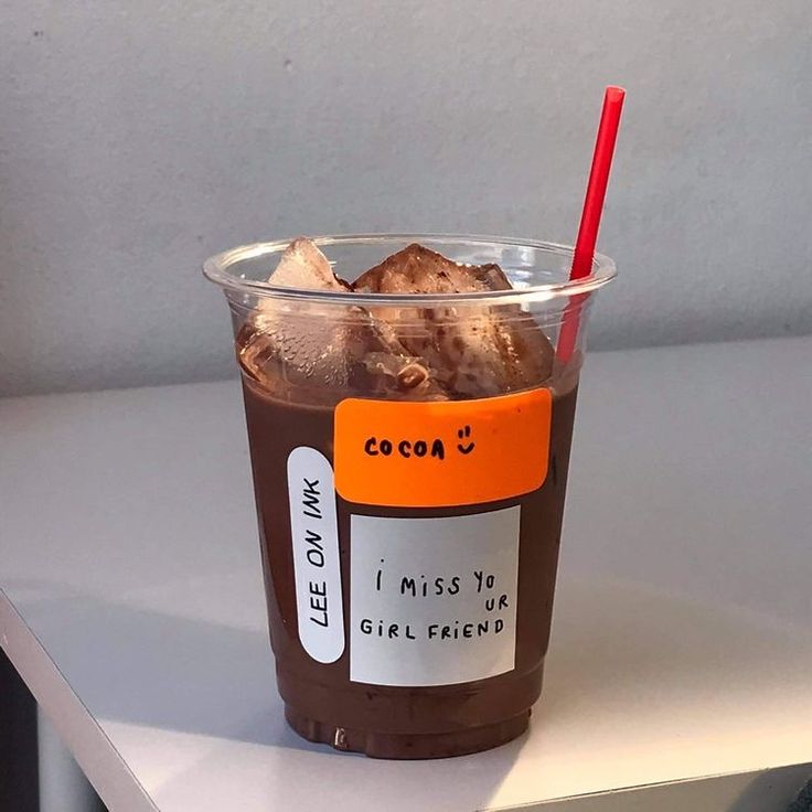 a plastic cup filled with ice cream and chocolate flavored dessert sitting on top of a white counter