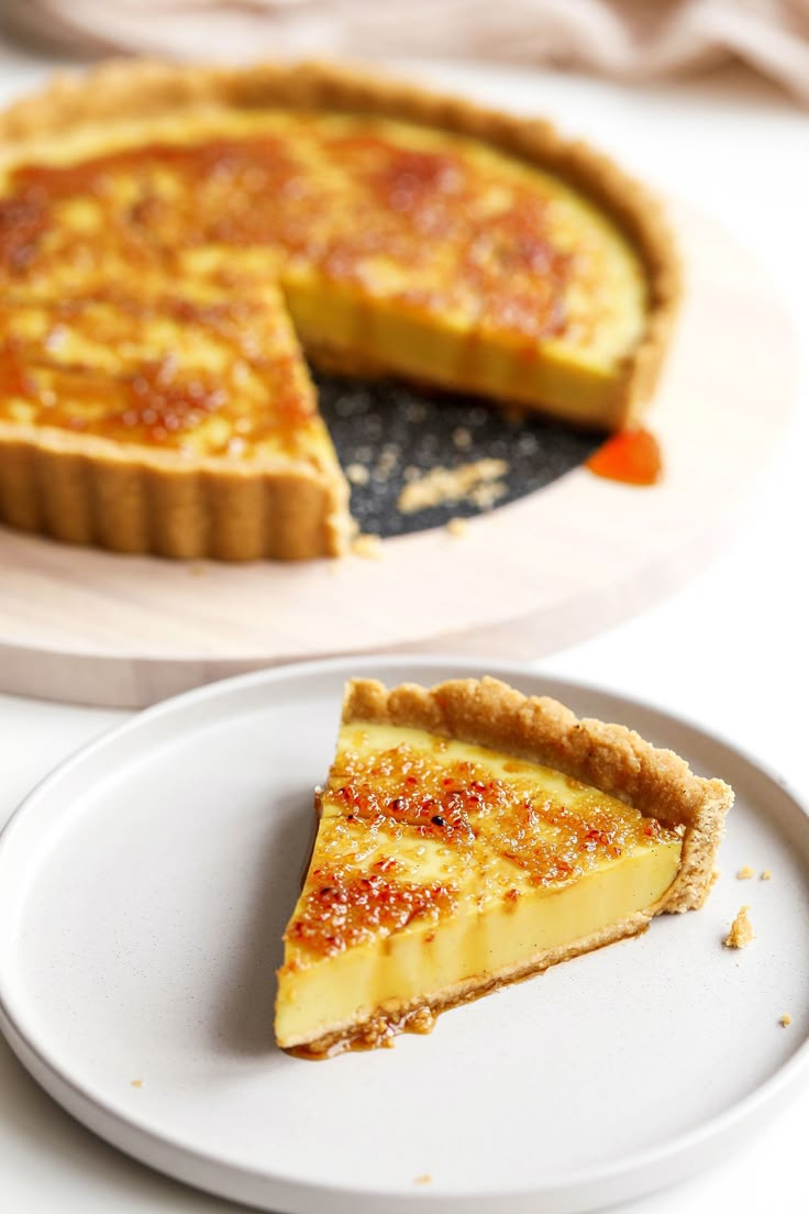 a slice of quiche on a plate next to the pie