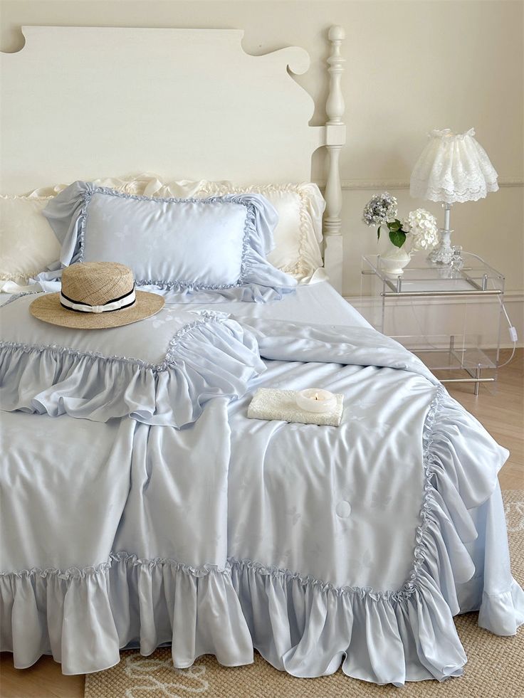 a bed with blue ruffled bedspread and pillows