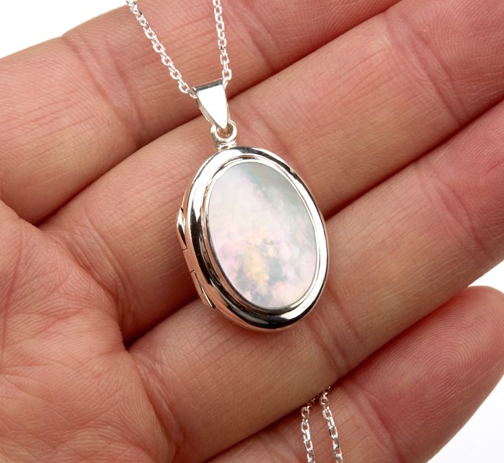 An oval sterling silver photo locket necklace with an oval bezeled mother of pearl on the front: 1. One shining, highly polished solid sterling silver locket (23 x 18* mm, 8 mm thick, 5.24 grams) * Dimensions measured without the bale. Its front has a piece of mother of pearl (19 x 13.5 mm) set in a raised bezel. Its back is plain and can be engraved with initials or a few words. 2. It has two photo slots insides. Photo insertion service available (selected/paid through the pulldown menu). If yo Cheap Sterling Silver Locket Necklace Gift, Luxury Silver Engraved Locket Necklace, Mother Of Pearl Necklace Locket, Oval Locket Necklace Silver, Silver Locket Necklace, Engraved Locket, Round Locket, Sterling Silver Locket, Oval Locket