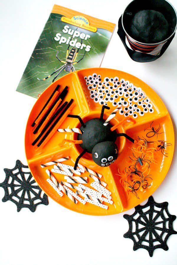 a plate with halloween decorations on it next to a cup and spider splats