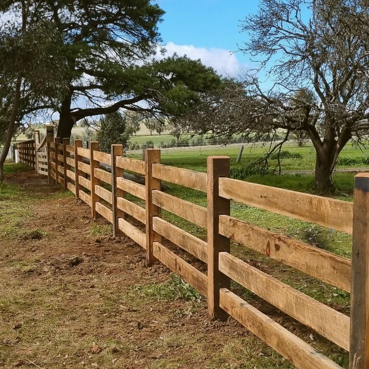 a wooden fence in the middle of a field