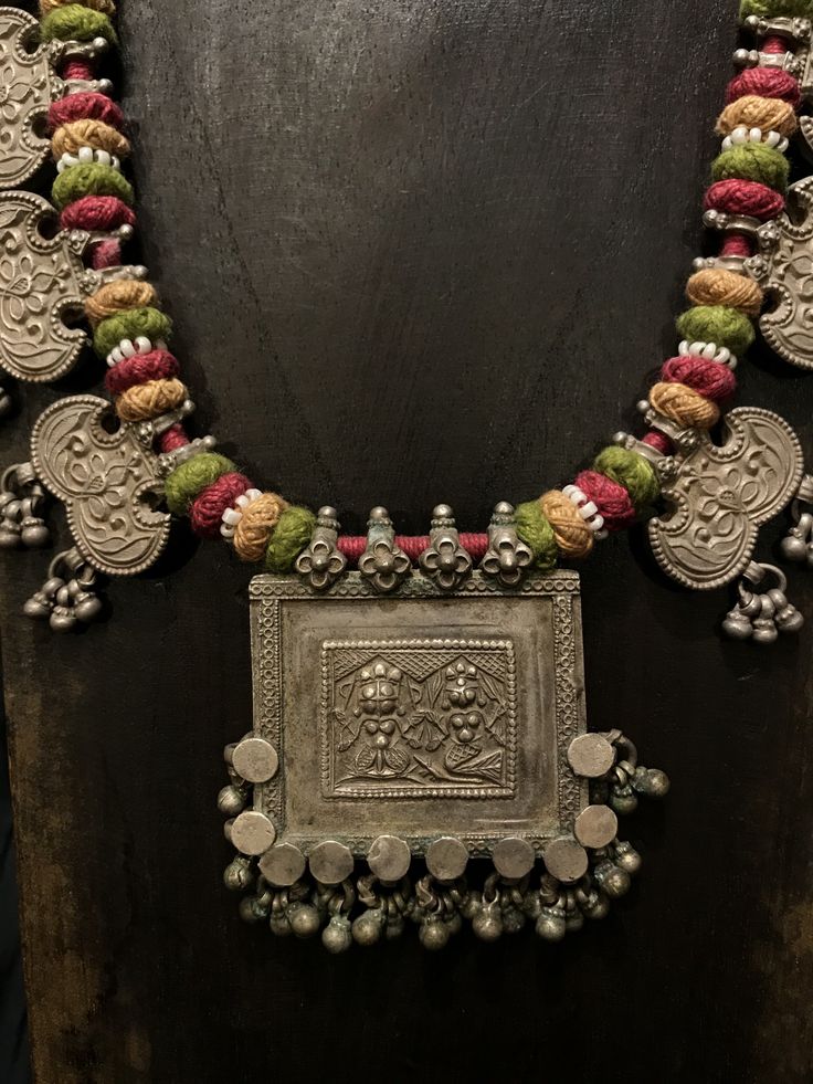 Get lost in the detail and unique beauty of antique silver Banjara beads strung onto a beautifully woven cord, handcrafted in India. All of our jewelry is one of a kind, handmade, and fair trade. A truly one of a kind piece, this necklace features the breathtaking intricacy of century old Banjara silverwork which is gracefully contrasted by the colorful and intricate woven cord they’re strung upon. The Banjara are one of the ancient nomadic tribes in India and have been known for centuries for t Antique Gold Jewelry Indian Necklaces, September Style, Tribes In India, Silversmithing Jewelry, Fabric Jewellery, Silver Bag, Antique Gold Jewelry Indian, Antique Jewellery Designs, Round Bead Necklace