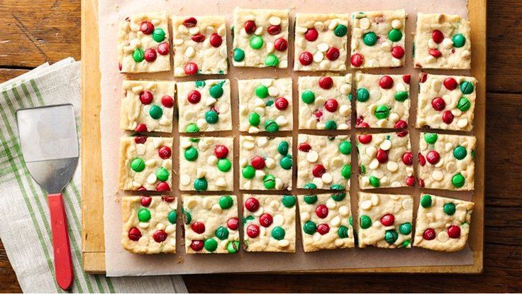 a cutting board topped with lots of cookies and candy