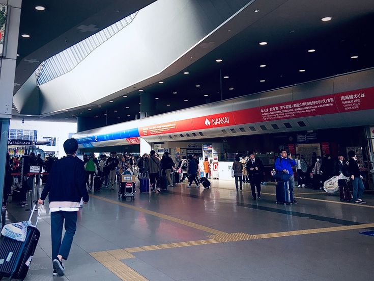 many people are walking through an airport with their suitcases in hand and luggage bags on the ground