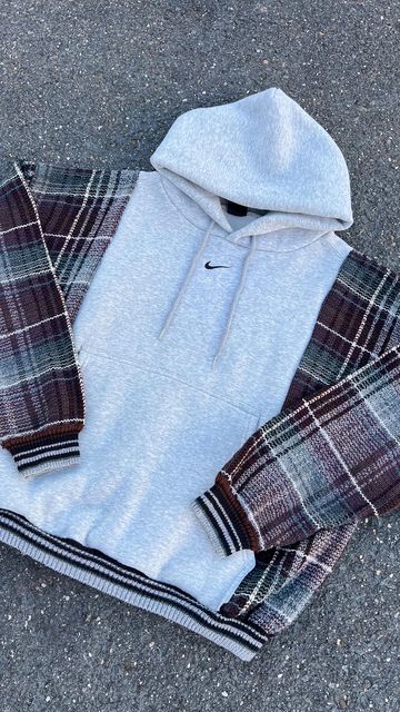 a gray hoodie and plaid pants laying on the ground