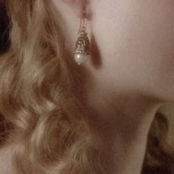 a close up of a woman's face wearing earrings