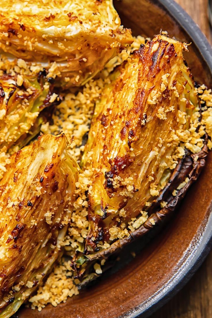 cooked artichokes with sesame seeds in a brown bowl on a wooden table