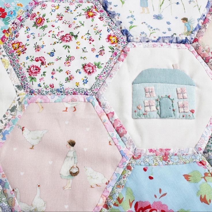 a patchwork quilt with many different designs on it, including flowers and houses in the center