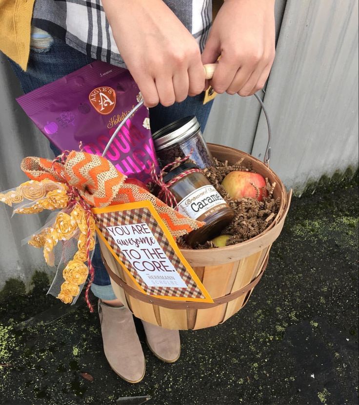 a person is holding a basket full of food and some sort of candy in it