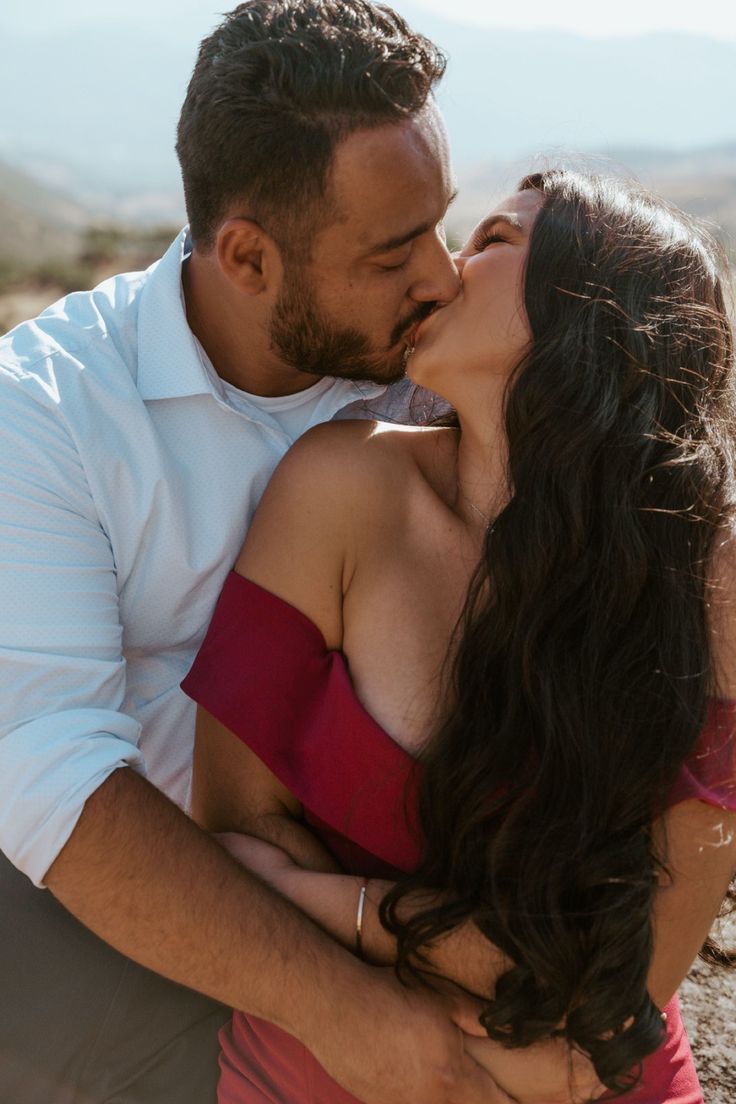 a man and woman kissing in the desert