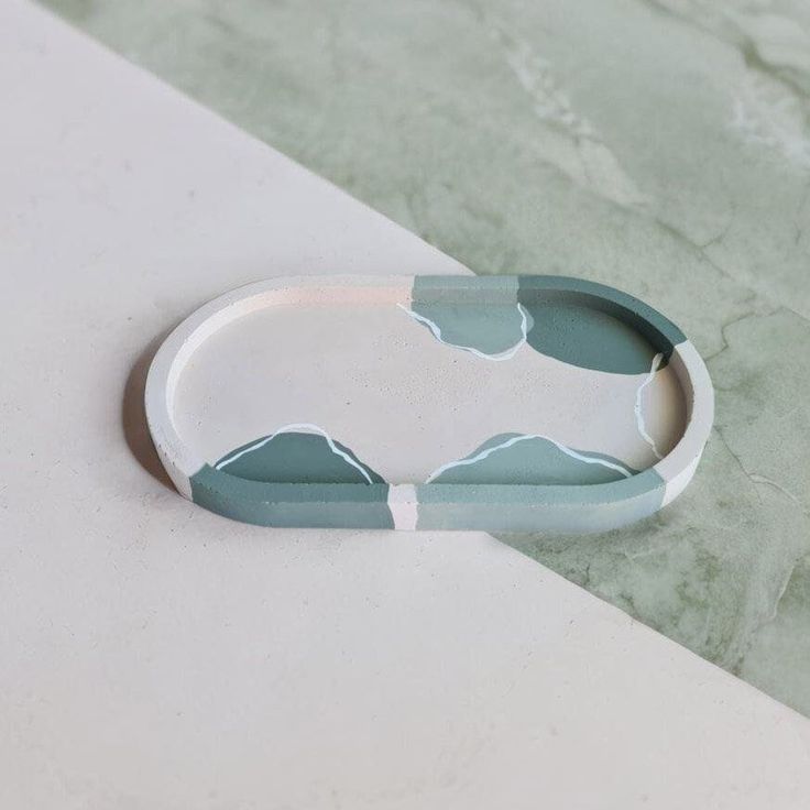 a white and blue bracelet sitting on top of a marble counter next to a wall