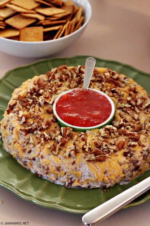 a cake with nuts and ketchup sitting on a plate next to bowls of crackers