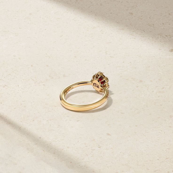 A glowing red ruby lays at the center of this meticulously crafted ring that's framed by a halo of twinkling round and baguette diamonds. Additional petite round diamonds sparkle along each end of the comfort fit shank to complete the look. Make this elegant and timeless adornment apart of your everyday jewelry rotation. Metal: 18kt Gold Ruby Weight: 0.60 ct. Round Diamond Weight: 0.25 ct. Baguette Diamond Weight: 0.22 ct. Measurements: 10.0 mm length *Please note that the listed ct. weights are Red Diamond Cluster Ring With Halo Setting, Timeless Ruby Ring With Diamond Center Stone, Red Ruby Ring With Baguette Diamonds, Red Diamond Ring With Baguette Cut, Baguette Cut Ruby Ring With Diamond Center Stone, Red Diamond Baguette Cut Rings, Baguette Cut Ruby Ring With Diamond, Timeless Ruby Ring With Diamond Prong Setting, Luxury Ruby Ring With Halo