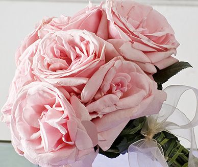 a bouquet of pink roses sitting on top of a table