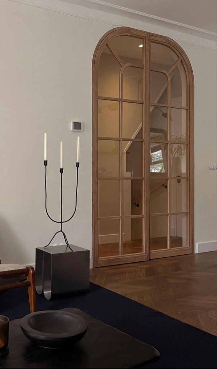 an empty room with two candles and a black plate on the table in front of it