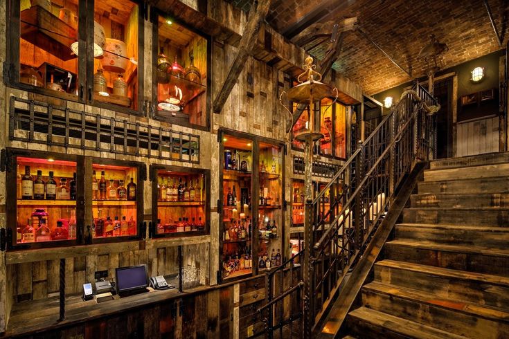 the inside of a building with wooden stairs and glass cases on the wall above it