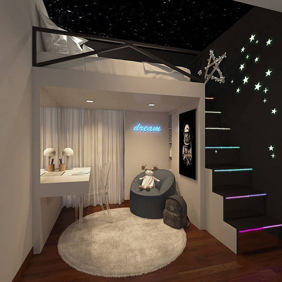 a room with stairs and stars on the ceiling, next to a white bed that has a gray chair in front of it