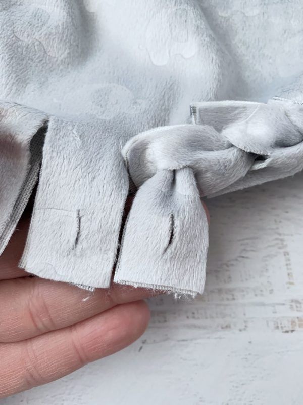 someone is holding the fabric off of their white robe with a knot on it's side