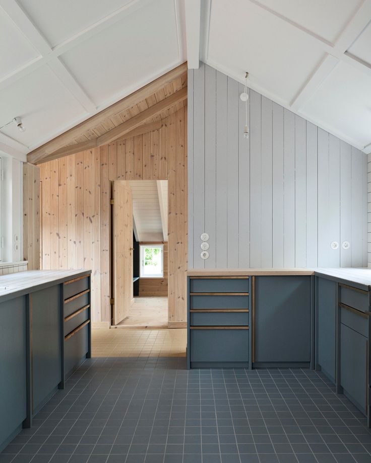 an empty kitchen with wood paneling on the walls and floor is pictured in this image