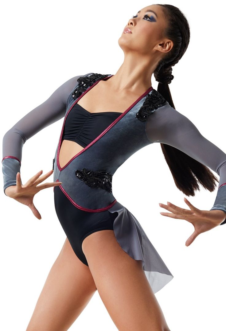 a woman in a black and grey leotard with her hands on her hips