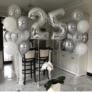 balloons and flowers are arranged in the middle of a room with large numbers on it