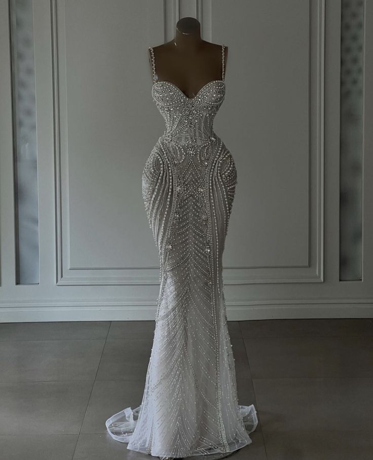 a wedding dress on display in front of a white wall