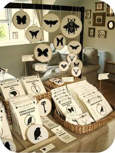 the table is full of plates and place mats with black silhouettes on them, hanging from strings