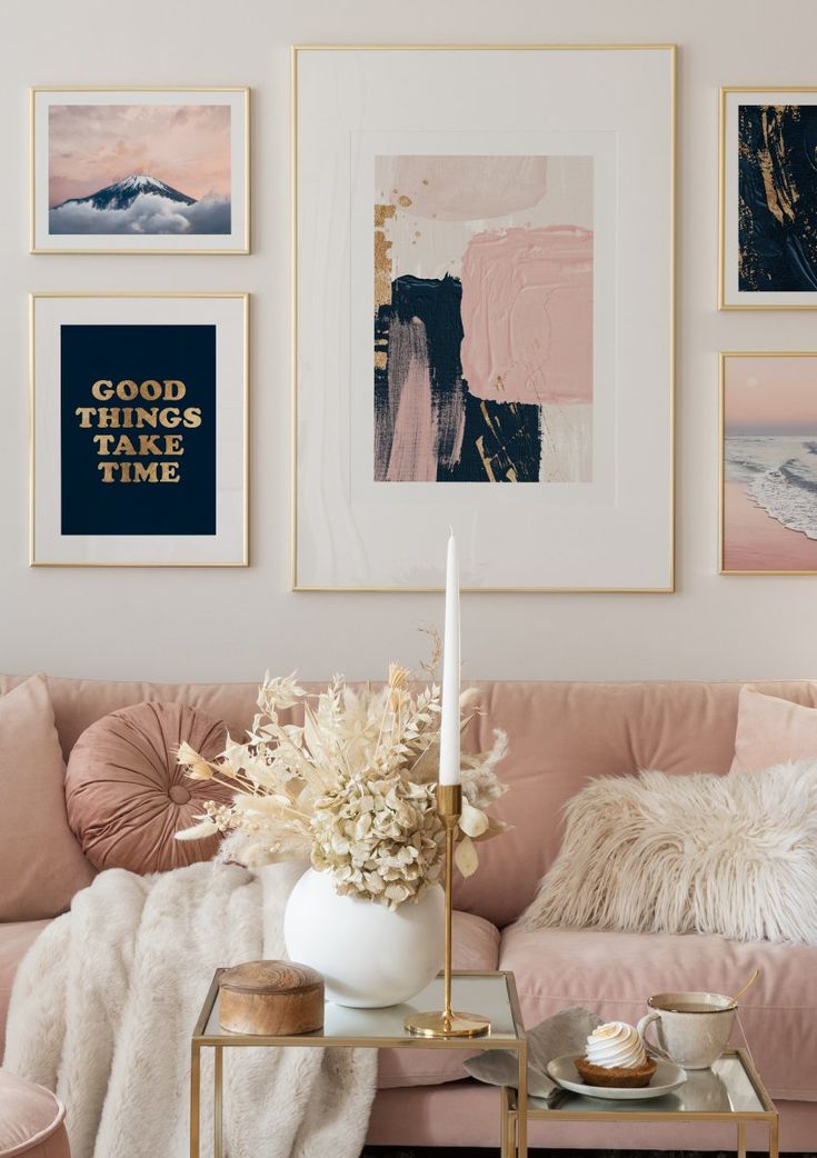 a living room with pink couches and pictures on the wall above them, along with a coffee table