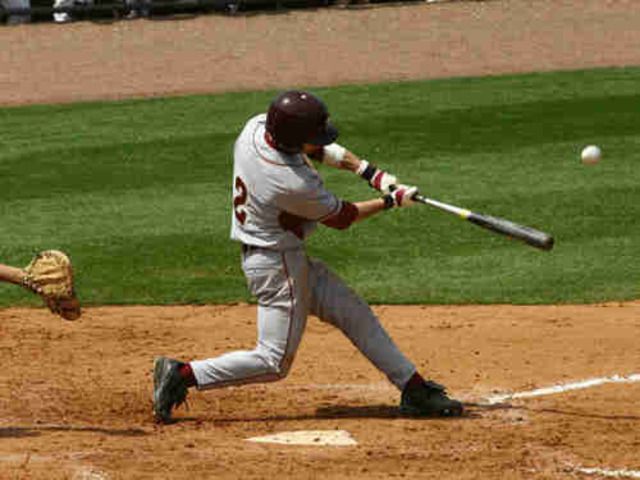 a baseball player swinging a bat at a ball