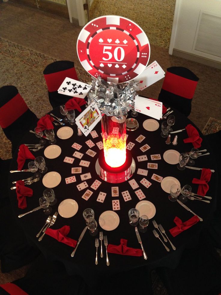 the table is set with poker cards and place settings for 50 guests to sit at