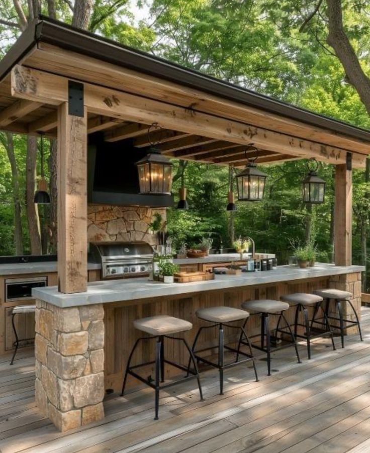 an outdoor kitchen with bar stools and grill