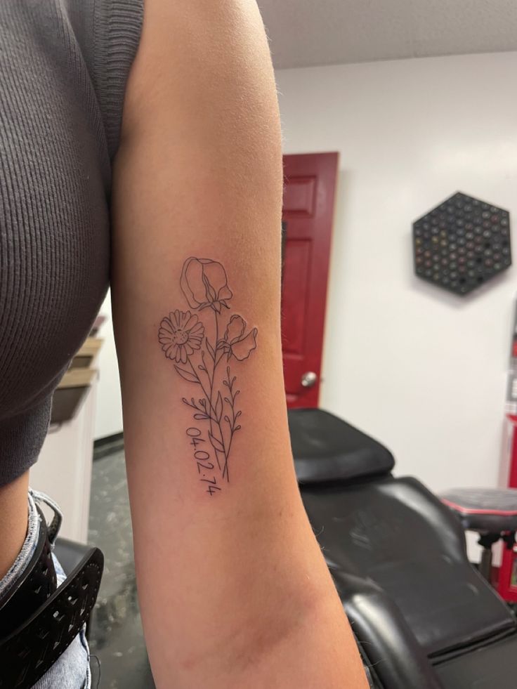 a woman's arm with a flower tattoo on the left side of her body