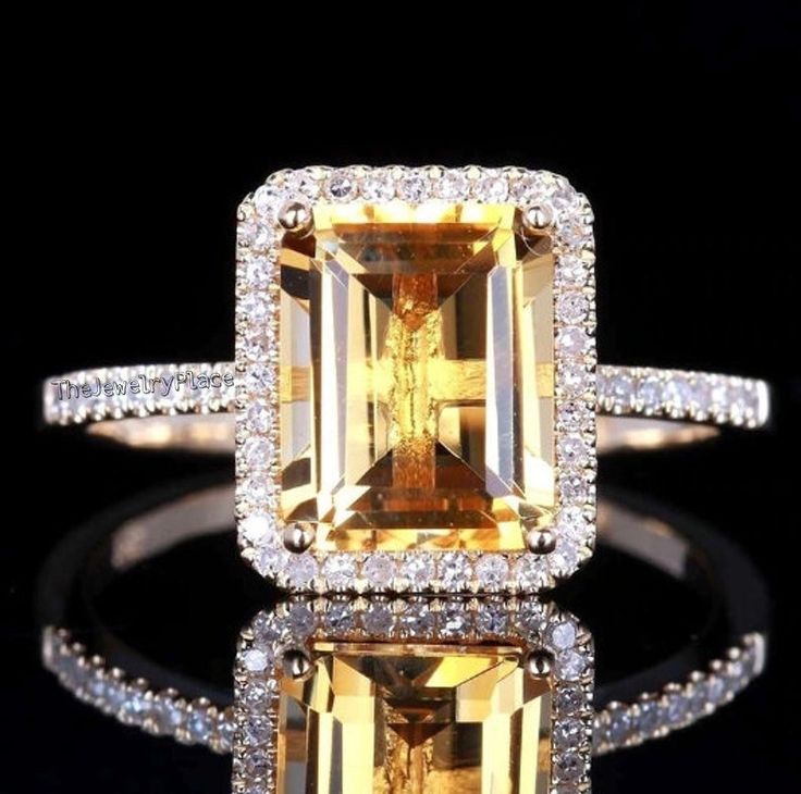 a yellow and white diamond ring with diamonds around it