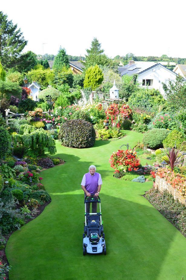 a man is mowing the lawn in his yard