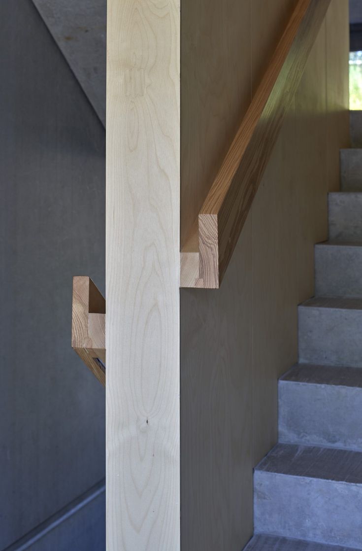 a wooden stair case next to a set of stairs