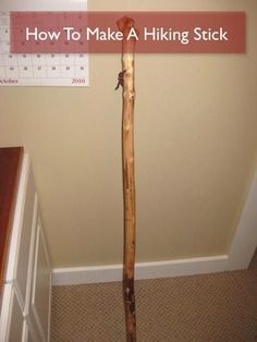 a wooden stick sticking out of the floor next to a wall with a calendar on it